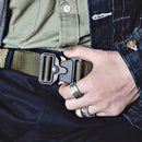 Man fastening a green tactical belt kit for men with a durable black metal buckle